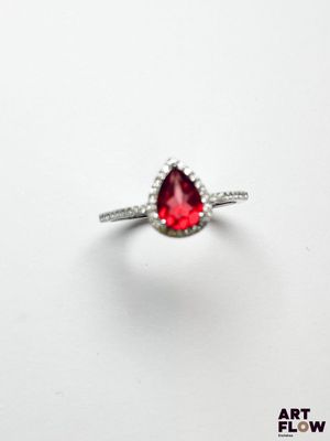 une image d'une bague sertie d'une pierre rouge en forme de poire