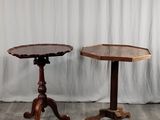 une paire de petites tables sur des socles, avec un rideau blanc en arrière-plan