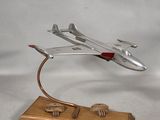 a silver model of a plane on a wooden stand