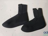 two pairs of black wetsuits are on a white surface