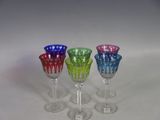 three wine glasses are lined up in a row on a white surface