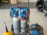 un chariot avec des bouteilles de gaz et des tuyaux posé par terre