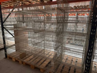 les nombreuses cages qui se trouvent sur les palettes dans l'entrepôt