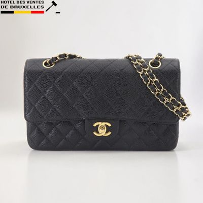 un sac à bandoulière Chanel en cuir matelassé noir, avec des finitions dorées