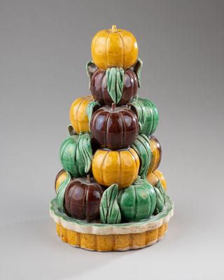 a ceramic sculpture of pumpkins stacked on top of each other
