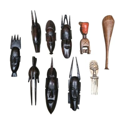 several wooden african masks are displayed on a white surface