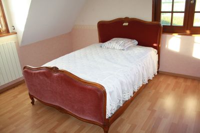 a bed with a red headboard in a small room