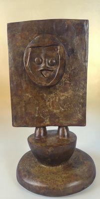 statue of a man with a face on a wooden base