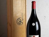 une bouteille de vin posée sur une table à côté d'une caisse en bois