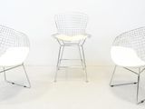 three white chairs sitting next to each other on a white floor