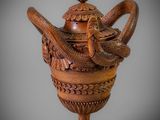 an image of a wooden vase with a snake on it
