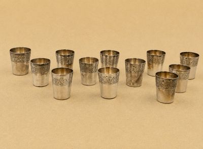 six verres à shot en argent alignés sur une table
