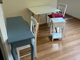 une petite table et des chaises dans une pièce au sol en parquet
