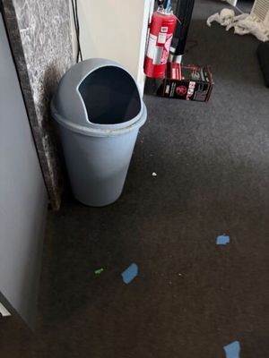 une poubelle posée dans un coin d'une pièce