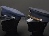pair of police hats on mannequin heads against a black background