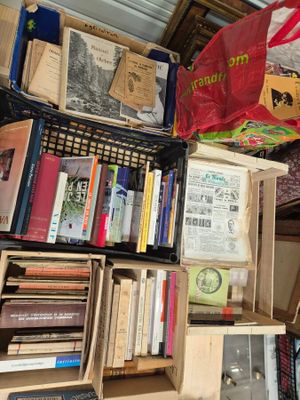 de nombreuses caisses de livres sur une étagère dans une pièce