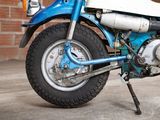 a blue and white motorcycle parked in front of a brick wall