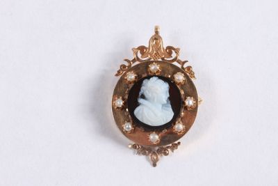 une image représentant une broche à l'effigie d'une femme avec des perles dans les cheveux