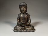 bronze statue of a person sitting in a meditation position