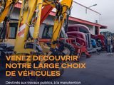a yellow excavator that is parked in front of a building