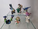 several figurines on a glass table with a white background