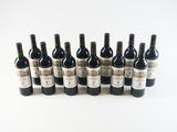 several bottles of wine are lined up in a row on a white surface