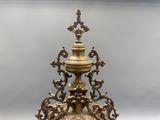 a gold clock on a stand on a white surface