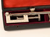 a silver colored telescope in a red case on a white surface