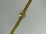 a gold watch on a white surface with a white background