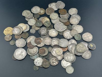 tas de vieilles pièces de monnaie posées sur une table, sur fond noir