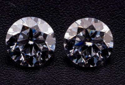 une paire de diamants taille ronde sur un fond noir