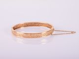 un bracelet en or avec une chaîne sur fond blanc