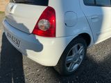 une petite voiture blanche garée sur le bord de la route