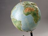 a blue and green globe on a black stand