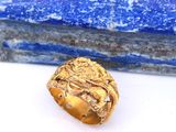 une image représentant une bague en or posée sur une pierre bleue