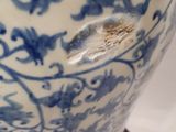 a large blue and white vase on a wooden stand