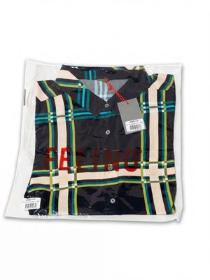 une chemise noire avec un motif à carreaux sur la poitrine et au col