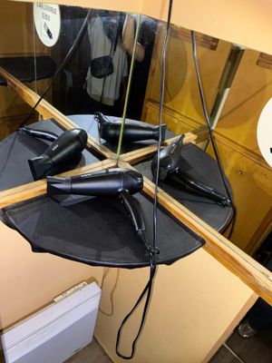 un miroir sur lequel sont posés des sèche-cheveux, dans une pièce