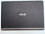 the back of a laptop with a black cover on a white surface