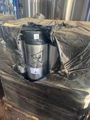 two kegs of beer are stacked on a pallet in a warehouse
