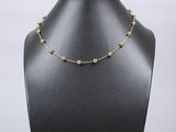 un mannequin noir portant un collier de perles dorées