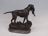 bronze statue of a dog with a bird in its mouth on a marble base