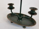 a green candle holder with three candles on it