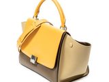 a yellow and brown handbag sitting on top of a white surface