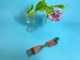 a glass of water and a spoon with a flower in it