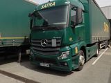 deux camions verts garés l'un à côté de l'autre sur un parking