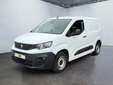 La camionnette blanche est garée dans une grande pièce.