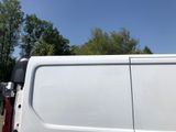 a white van parked in a parking lot with trees in the background