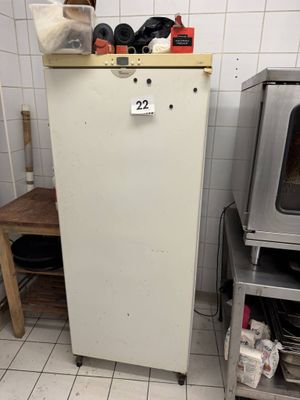 un réfrigérateur dans une cuisine dont le dessus est encombré