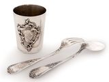 two spoons and a fork sitting next to a cup